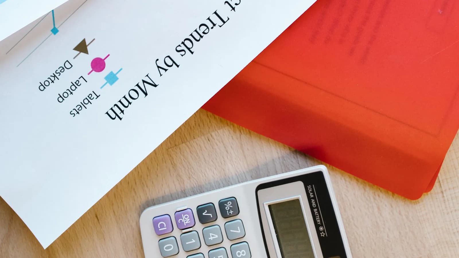 Calculadora y documentos de planificación sobre una mesa Calculadora y documentos de planificación sobre una mesa